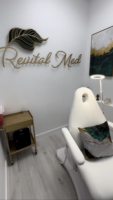 A private treatment room at Revital Med Spa with the gold Revital Med logo on the wall